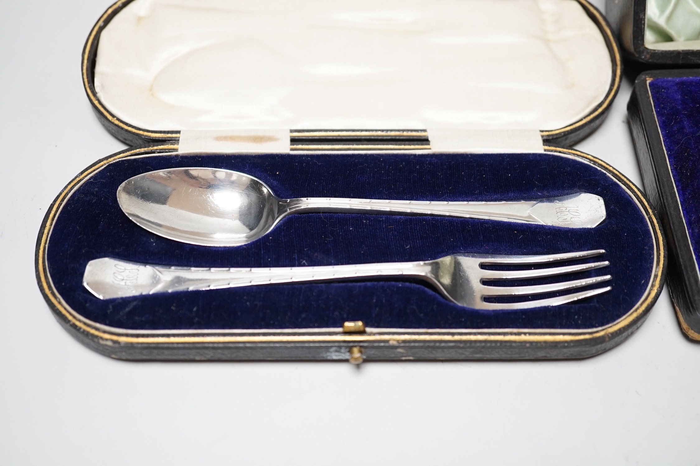 A cased George V silver christening trio, by Walker & Hall, Sheffield, 1925 and a cased silver christening spoon & fork, Henry Wigful, Sheffield, 1925.